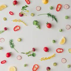 Colorful food pattern made of lemon, tomoatoes, red pepper and yellow flowers. Flat lay.