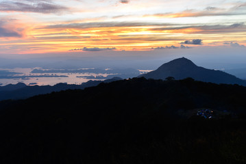 Campfire smoke from camping site at beatiful place, mountain peak at sunnset.