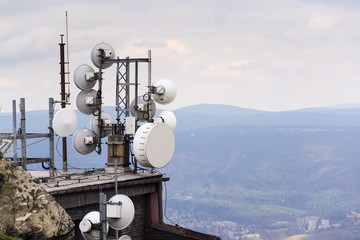Telecommunication transmitters and aerials with city in background