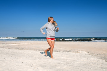 Fototapeta na wymiar Woman running on the beach. Female runner jogging. .
