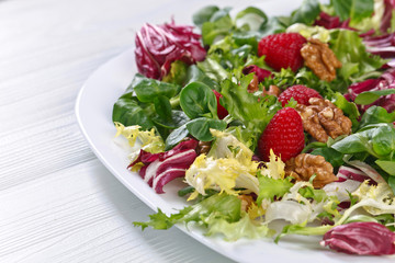 Vegan spring salad with raspberries and nuts