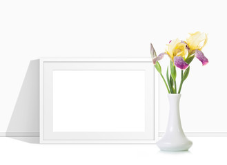 Beautiful  iris flowers in vase and photo frame mockup
