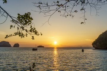 Spectacular sunset over sea and boats on Phra Nang beach