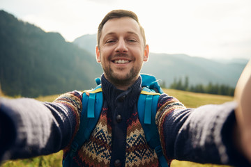 Smiling hiker taking a selfie in the great outdoors - Powered by Adobe
