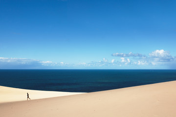 man walk alone over Dunes in a sunny day at Carlo Sandblow Rainbow Beach.
