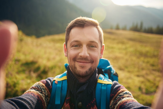 Smiling man taking a selfie while out hiking