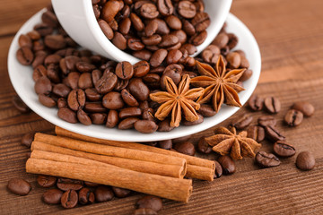 Coffee beans and cinnamon on a background of burlap. Roasted coffee beans background close up. Coffee beans pile from top with copy space for text. Seasoning. Spice. Cinnamon. Badian. Coffee house.