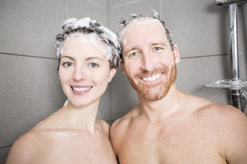 Young couple washing their heads in the shower