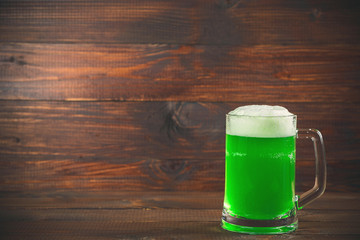 St Patrick's Day concept mug green beer against wooden background
