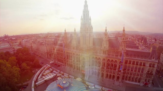 Vienna's beautiful Rathaus City Council building aerial, local government, Europe tourist center, famous tourism attraction, sunset drone fly over, flare in lens, moving aerial camera, Austia capital