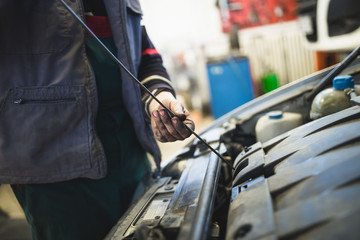 Close up hands of unrecognizable mechanic doing car service and maintenance.