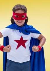 Fototapeta premium Kid pretending to be a superhero against yellow background