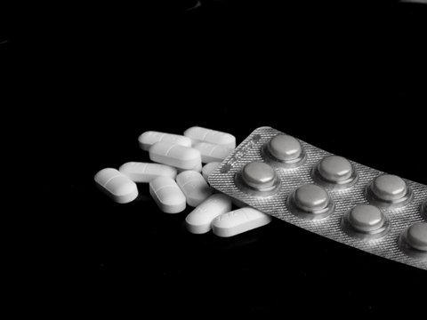 Medical pills on black background
