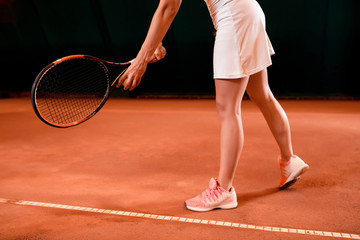 Fototapeta na wymiar Legs of female tennis player on tennis court