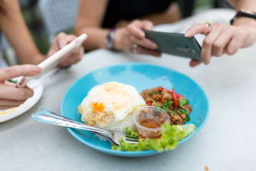 Friends taking photo on thai food dishes before eating