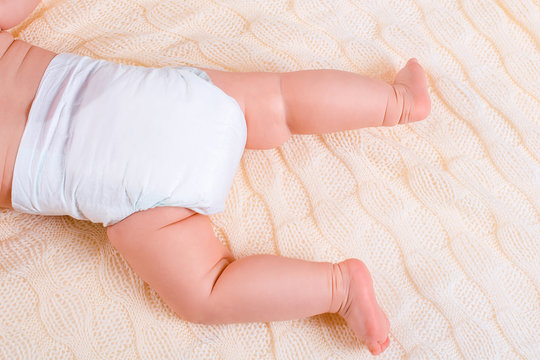 feet of a six months old baby wearing diapers