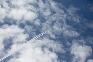Airplane trail above the blue sky