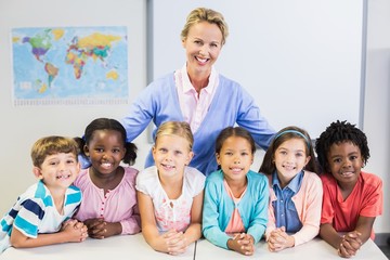 Portrait of teacher and kids in classroom