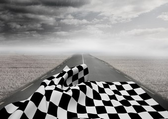 Checkered flag on road against stormy sky
