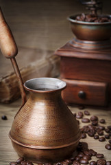 Old cooper ibrik for turkish coffee with coffee beans and ginger