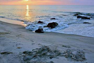 Fototapeta premium Scenic Summer Sunrise Over Rock Jetty on the Beach