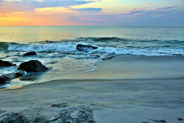 Fototapeta premium Scenic Summer Sunrise Over Rock Jetty on the Beach