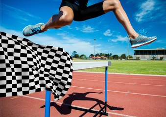 Athlete jumping over hurdles at the finish line