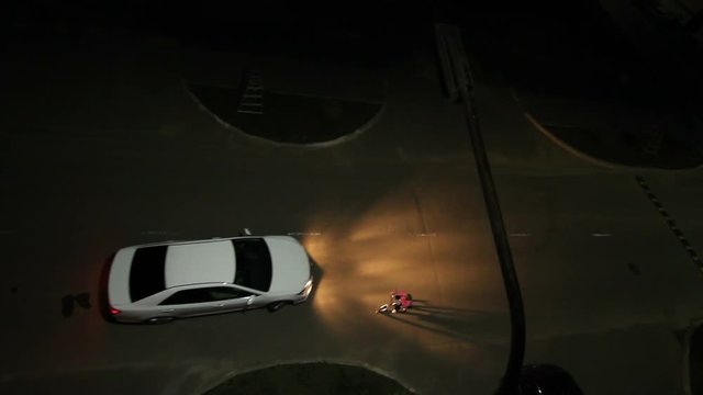 Wideshot Top View Car Headlight to Illuminate  Child on Bicycle