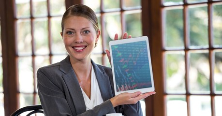 Woman holding digital tablet against window in background