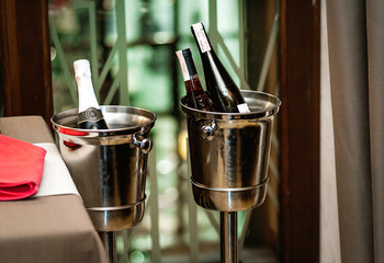 bottle of wine is being cooled in the pail with ice