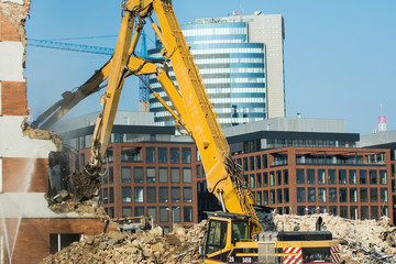 Demolitions old building in center city with heavy equipment