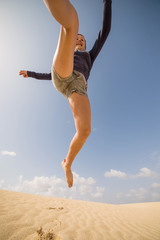 Fototapeta premium jeune femme bondissant dans les dunes