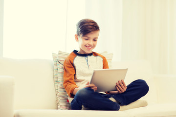 smiling boy with tablet computer at home