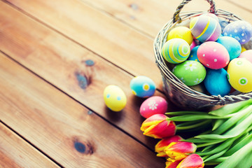 close up of easter eggs in basket and flowers