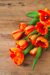 Naklejka na ściany i meble The beautiful orange tulips on a light gray wooden table. Spring flowers. Beauty and tenderness of nature. Great gift to a woman.