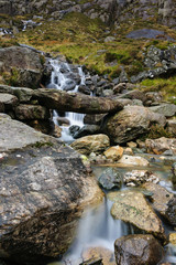 A small mountain stream and primitive stone bridge on the Cwm Idwal track in the Snowdonia National Park in North Wales. Shot with a long exposure to accentuate the flow of the water