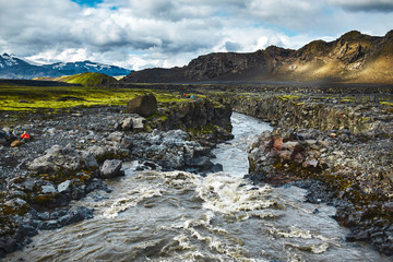 Travel to Iceland. Beautiful Icelandic landscape with river, mountains, sky and clouds. Trekking in...