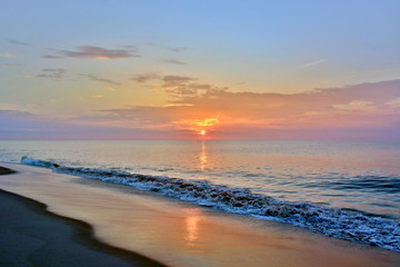 Fototapeta premium Uspokajające letnie morze o wschodzie słońca na brzegu