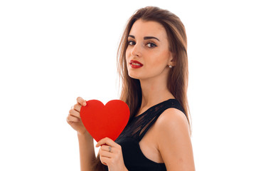 sexy young girl with red lipstick is holding a card in the shape of a heart and looking directly