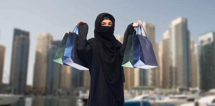 muslim woman in hijab with shopping bags in dubai