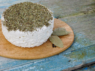 Soft goat cheese with herbs on the old blue wooden table