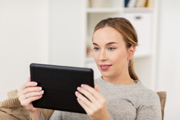 smiling woman with tablet pc at home