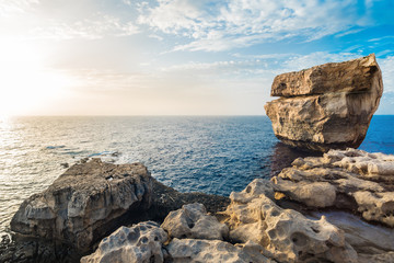 Fototapeta na wymiar Rocky sea coast, beautiful stone formation in the water, sunset.