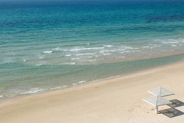Fototapeta na wymiar Top view of aquamarine sea and empty beach. Travel and vacation concept.