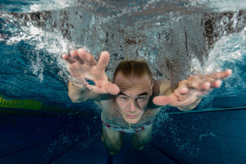 Young swimmer swimming in a pool underwater