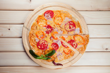 Spicy pizza on a wooden background