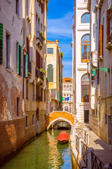Traditional narrow canal with gondolas in Venice, Italy