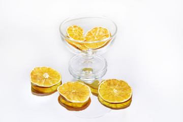 Glass dishes on mirror with reflection.