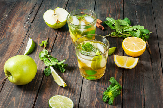 homemade lemonade with lime, mint in a glass on a wooden rustic table
