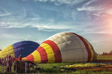 Obraz premium Start of big hot air balloons at the field with cool cloudy sky